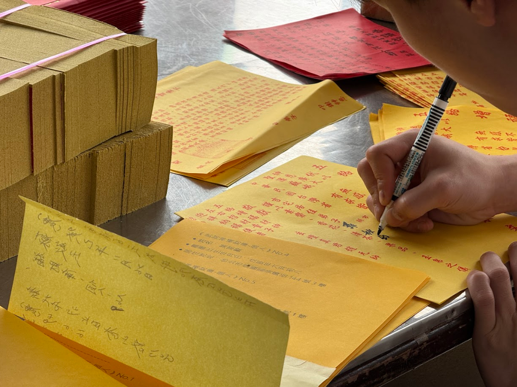 隨壇人員為線上登記信眾書寫補財庫法事疏文。照片來源/我的手機隨手拍